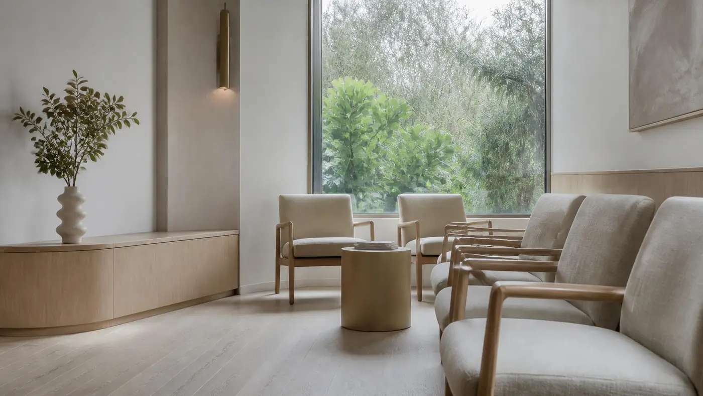 A quiet clinic reception, morning light across a pale timber counter